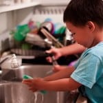 child washing dishes