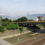 river, train tracks, bridge with Medellin hills in background