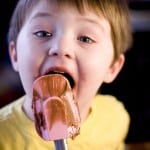 boy licking spatula with chocolate