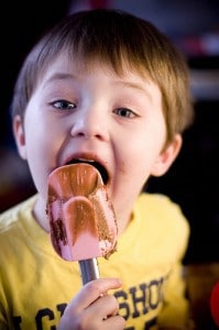 boy licking spatula with chocolate