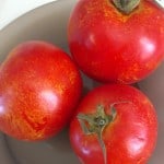 three ripe fresh tomatoes with yellow speckles