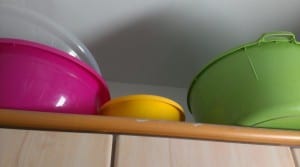 large mixing bowls on top of the cabinet 